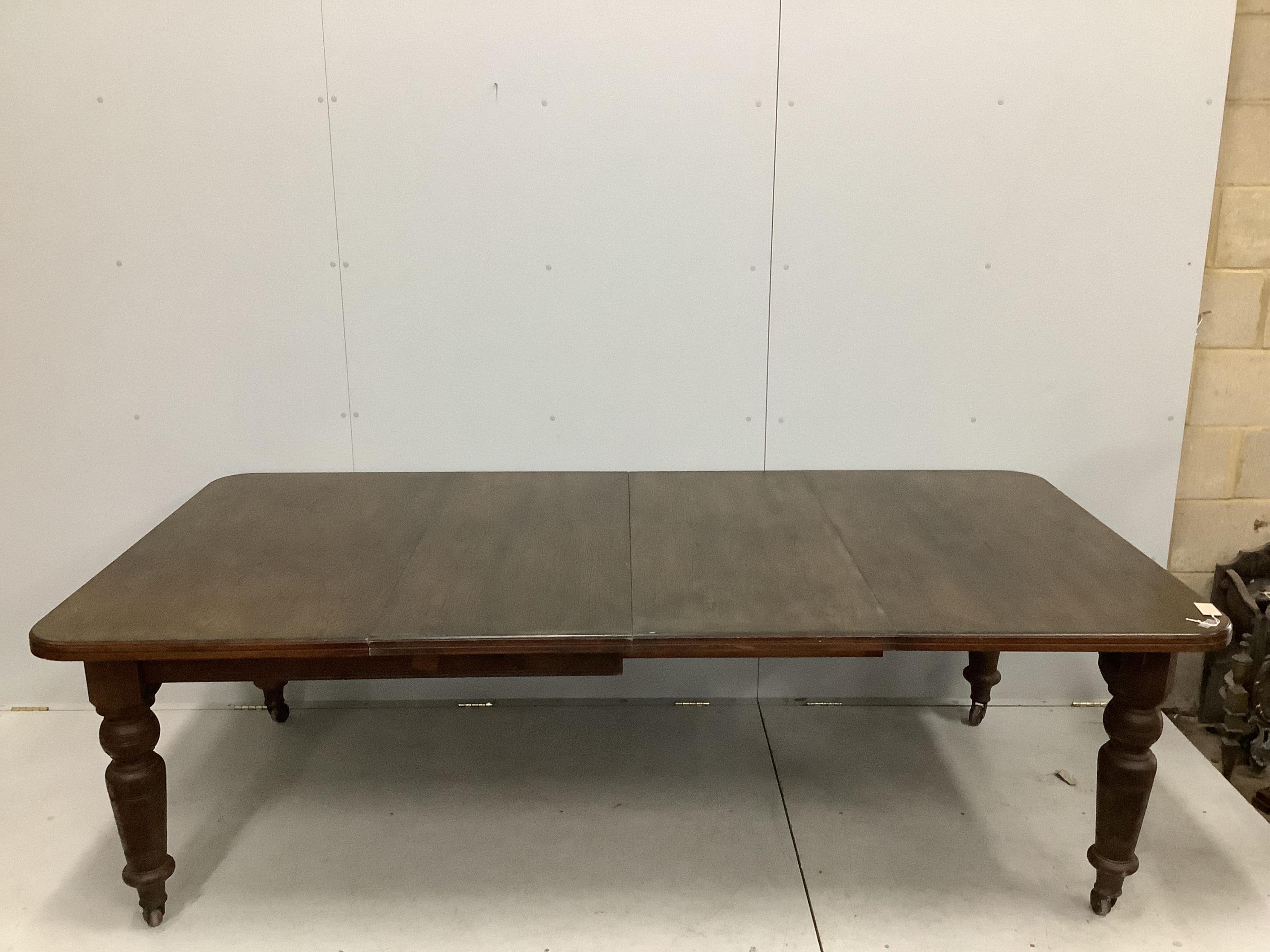 A late Victorian oak extending dining table, width 240cm extended, two spare leaves, depth 120cm, height 74cm. Condition - fair